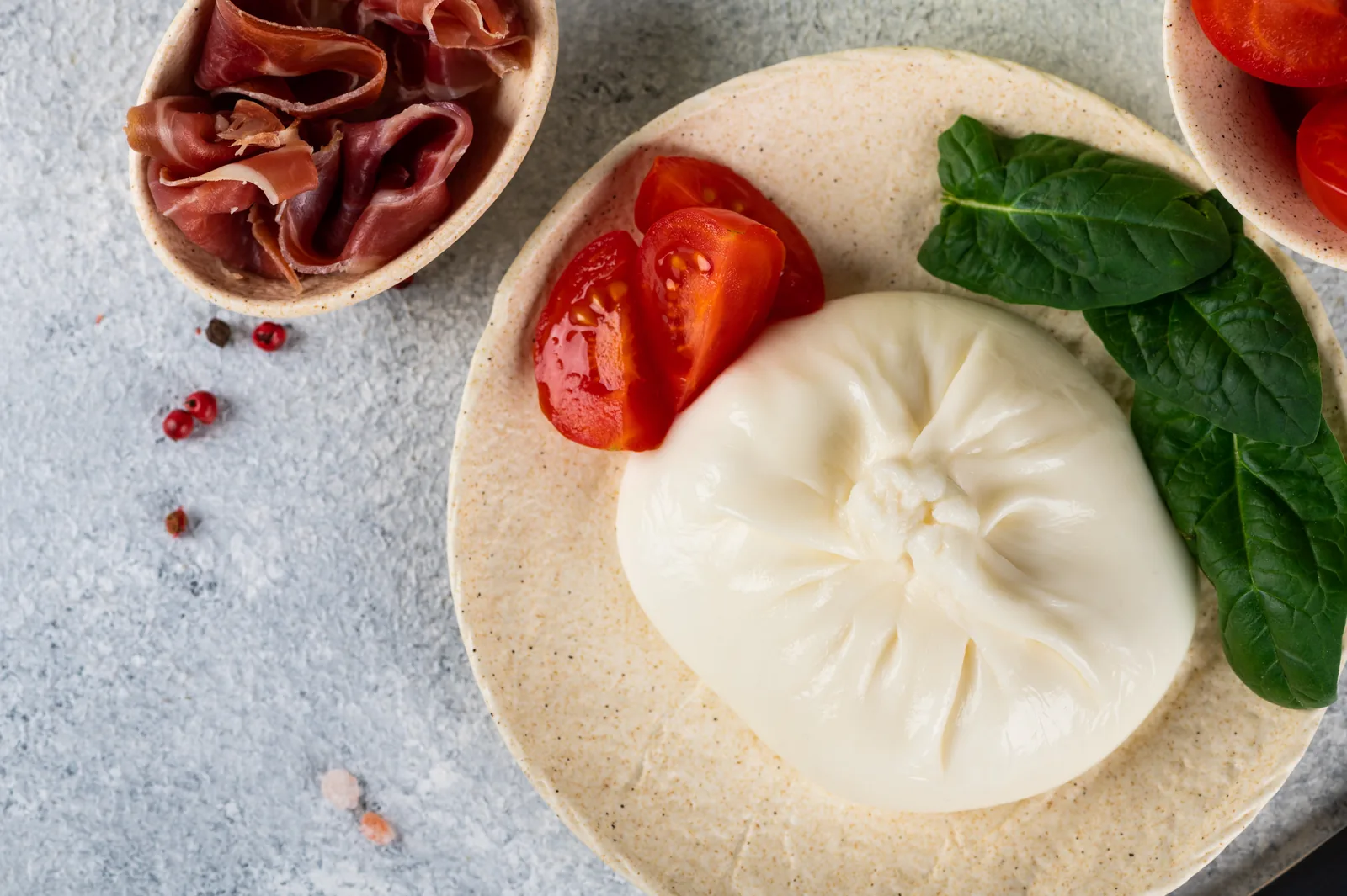 Domates, yeşil yapraklar ve prosciutto ile burrata peyniri