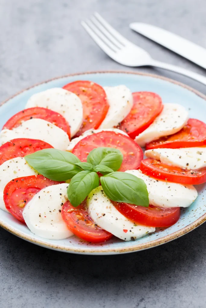 Dilimlenmiş mozzarella, domates ve fesleğenli Caprese salatası
